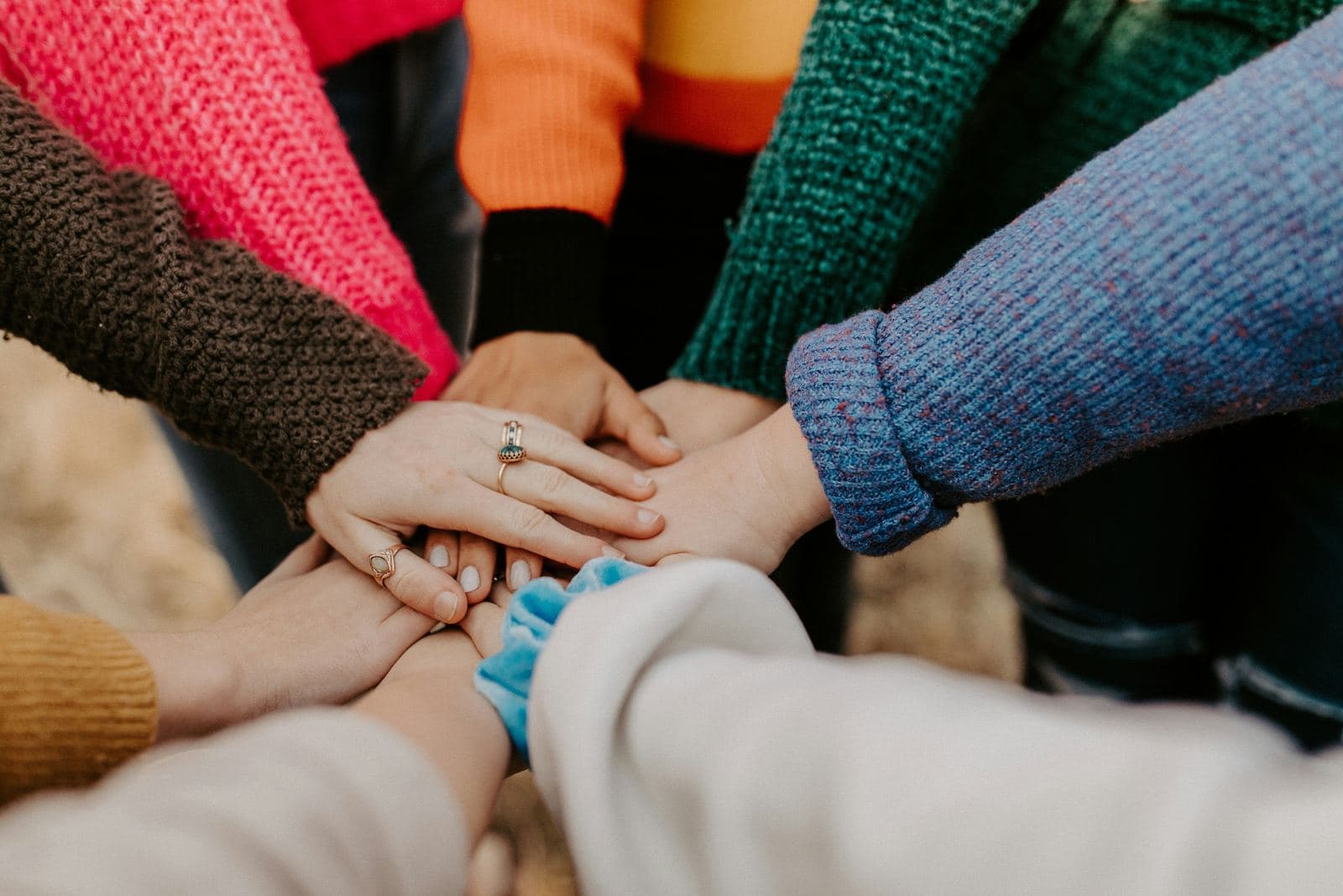 Team members placing their hands together