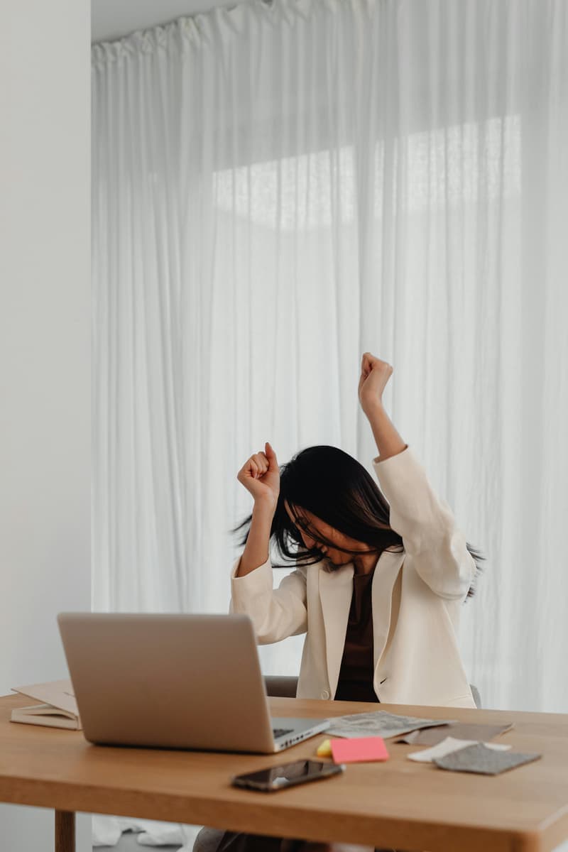 Self-employed applicant celebrating at a laptop